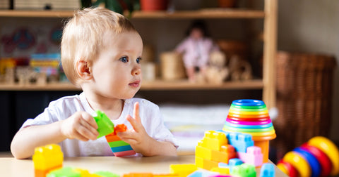 Baby girl organizing her plastic toys