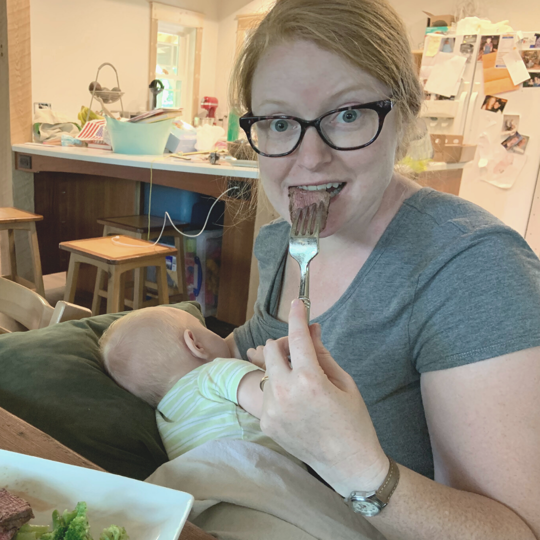 working mom eating with a fork while baby breastfeeds